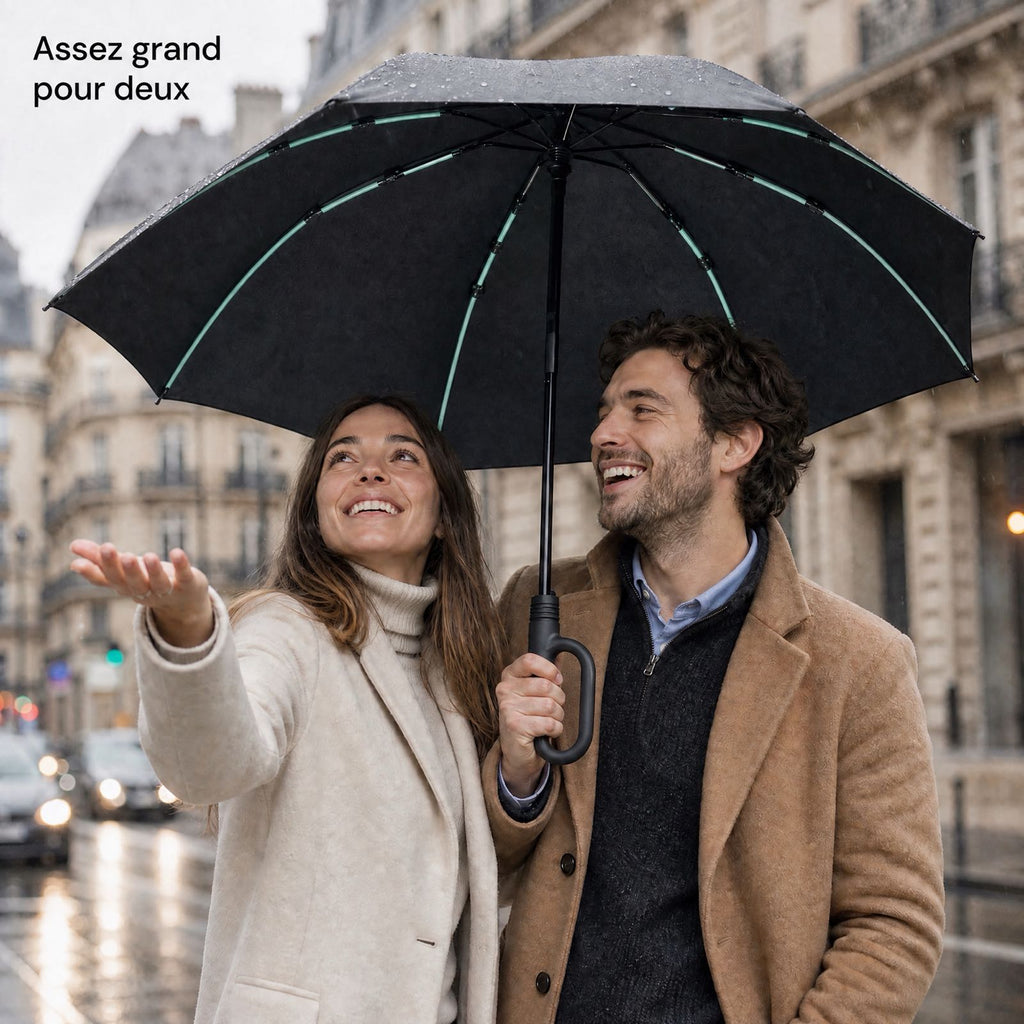 Couple sous le parapluie Tokyo™ noir dans une rue parisienne sous la pluie.