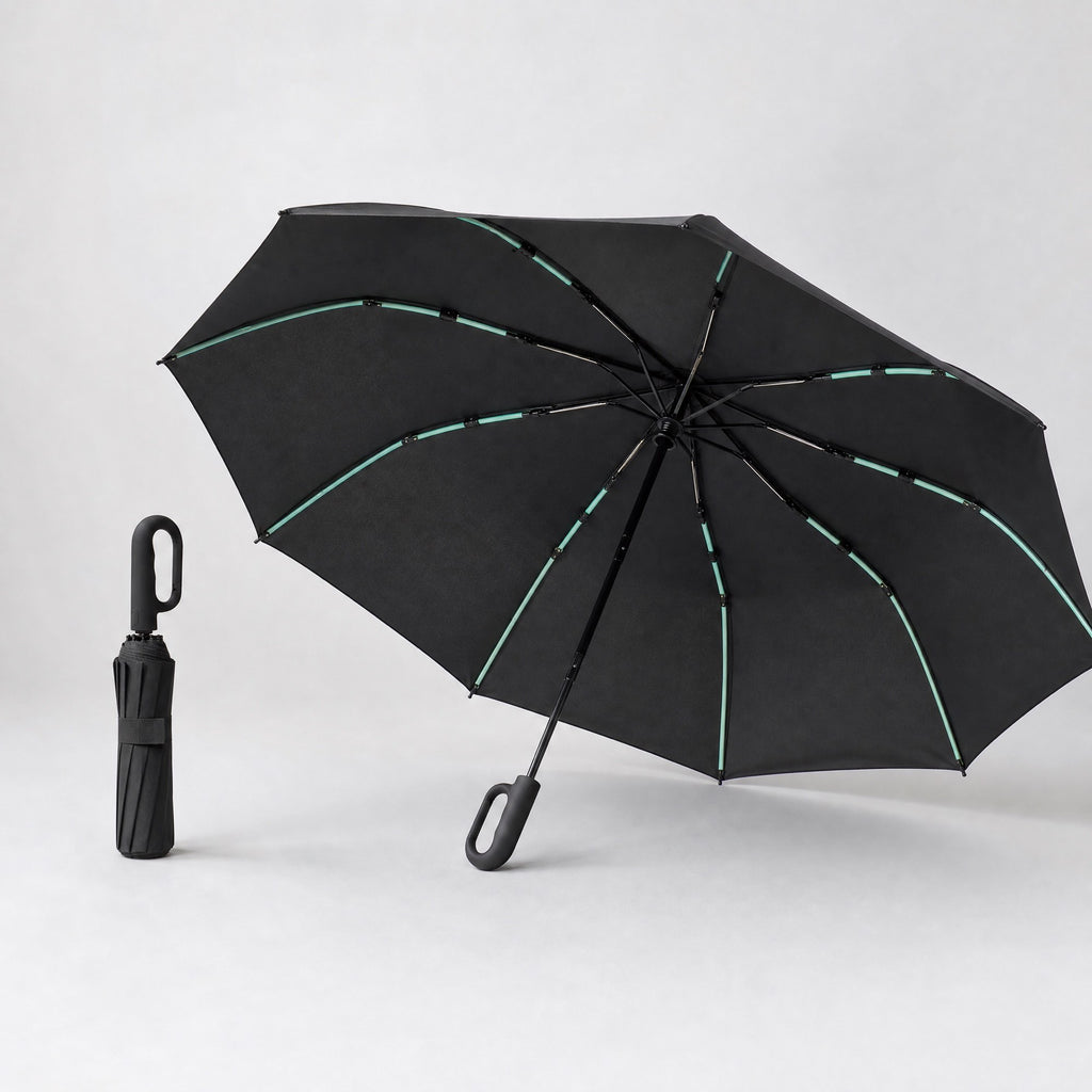 Parapluie Tokyo™ noir, ouvert en trois quarts et plié debout, sur fond studio clair.