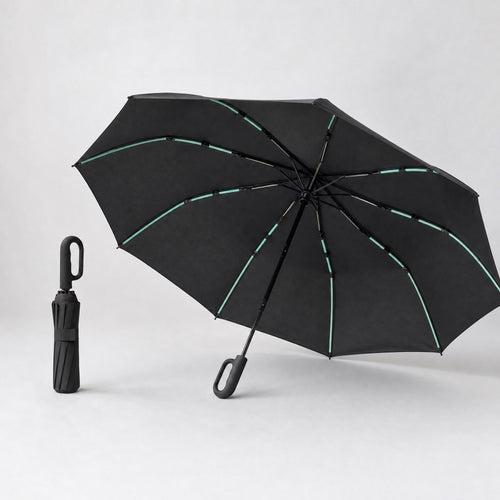 Parapluie Tokyo™ noir, ouvert en trois quarts et plié debout, sur fond studio clair.