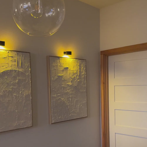 Appliques murales LED Lumora™ allumées dans un salon, une chambre et une cuisine